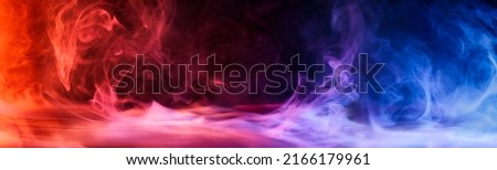 Dramatic smoke and fog in contrasting vivid red, blue, and purple colors. Vivid and intense abstract background or wallpaper. Royalty-Free Stock Photo #2166179961