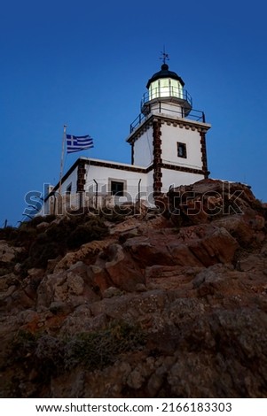 The old lighthouse on the rocky cliff at night