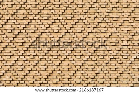 Geometric brickwork on the wall of a historic building in a narrow street in the Medina, Tozeur, Tunisia. Royalty-Free Stock Photo #2166187167
