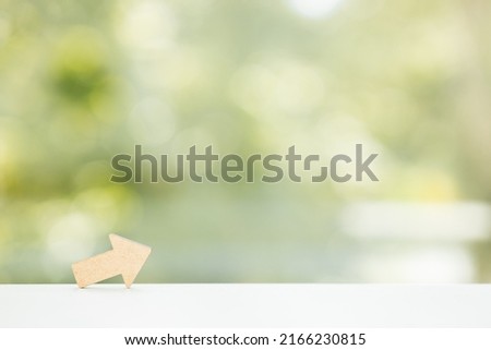 Wooden arrows point on green summer background