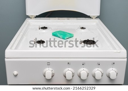 a rag and gel lie on the gas stove during cleaning. High quality photo