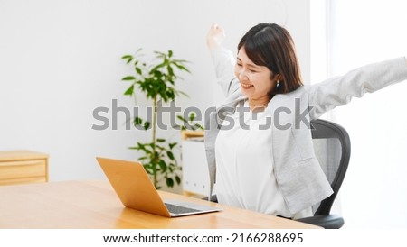 Young businesswoman stretching in her office