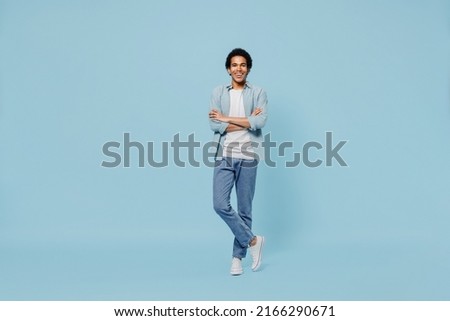 Full size body length cheerful fascinating happy fun blithesome young black curly man 20s years old wears white shirt hold hands crossed isolated on plain pastel light blue background studio portrait Royalty-Free Stock Photo #2166290671