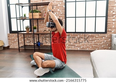 Young hispanic man training yoga exercise at home