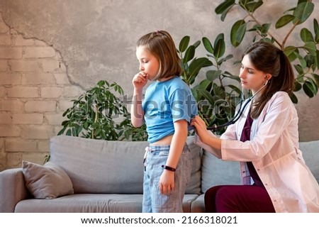 Child Girl Suffers from Dry and Wet Cough. Complaint Breathing Discomfort. Auscultation Lungs Exam with Stethoscope. Woman Pediatrician in Pediatric Medical Office with Young Female Patient Royalty-Free Stock Photo #2166318021