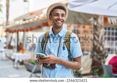 African american man tourist smiling confident using smartphone at street Royalty-Free Stock Photo #2166321621
