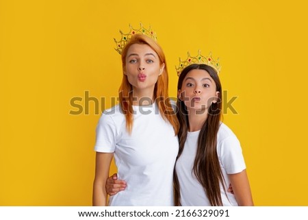 Cheerful mother and daughter wearing crown at family party. Funny girls with crown, isolated background.