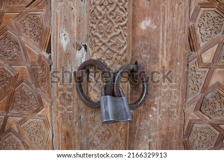 Old decorated wooden door with padlock, madrassa, Bukhara, Uzbekistan, Central Asia