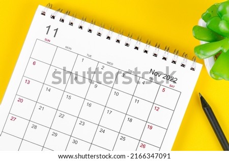 Close-up November 2022 desk calendar on yellow background.