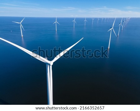 Offshore Windmill farm in the ocean Westermeerwind park, windmills isolated at sea on a beautiful bright day Netherlands Flevoland Noordoostpolder. Huge windmill turbines Royalty-Free Stock Photo #2166352657