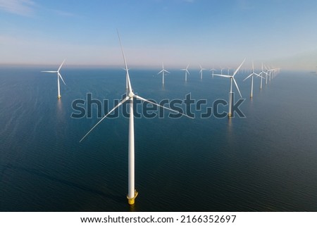 Offshore Windmill farm in the ocean Westermeerwind park, windmills isolated at sea on a beautiful bright day Netherlands Flevoland Noordoostpolder. Huge windmill turbines Royalty-Free Stock Photo #2166352697