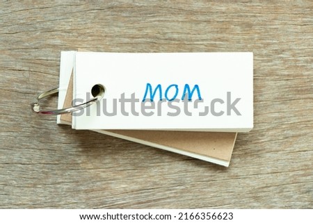 Flash card with handwriting word mom on wood background