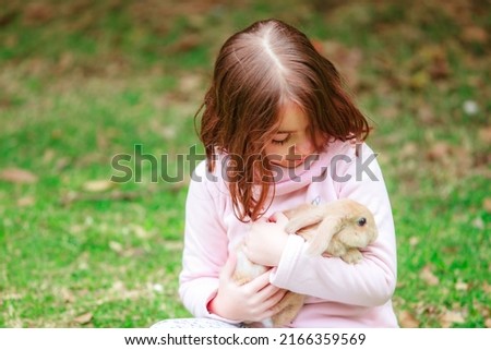 Hispanic girl with a rabbit in the park