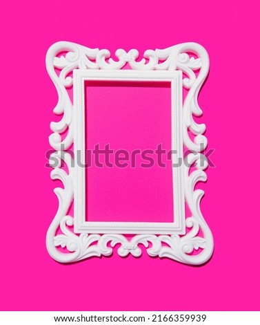 Neon pink color background and white ornate frame. Creative copy space. 