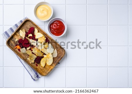 Dried vegetables chips set, on white ceramic squared tile table background, top view flat lay, with copy space for text