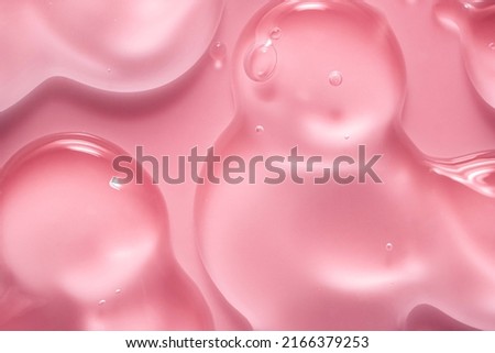 Cream gel drops red transparent cosmetic sample texture with bubbles on pink background Royalty-Free Stock Photo #2166379253