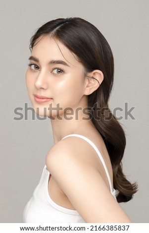 Beautiful young Asian woman model with perfect clean fresh skin on grey background. Face care, Facial treatment, Cosmetology, Plastic Surgery, Lovely girl portrait in studio. Royalty-Free Stock Photo #2166385837