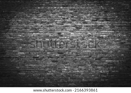 Background of old black and white vintage dirty brick wall. Empty brick texture with vignetting. Grunge grey stonewall. Design element. Copy space.