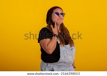 Plus size woman in stylish clothes in studio photos, with facial expressions.