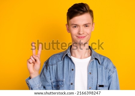 Photo of young handsome man show fingers peace cool v-symbol vacation isolated over yellow color background