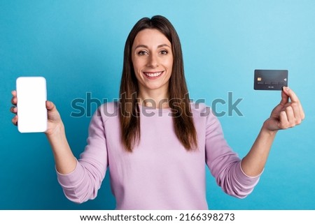 Photo of young pretty woman show mobile credit card benefit app download cashback isolated over blue color background