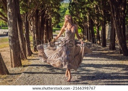 Woman tourist walking in Montenegro. Panoramic summer landscape of the beautiful green Royal park Milocer on the shore of the the Adriatic Sea, Montenegro