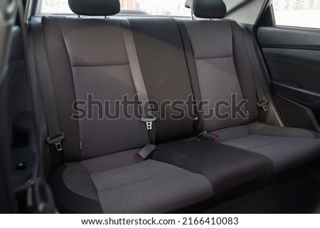 Close-up on rear seats with velours fabric upholstery in the interior of an old Korean car in gray after dry cleaning. Auto service industry. Royalty-Free Stock Photo #2166410083