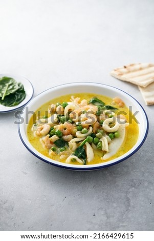 Homemade seafood curry with spinach and green pea Royalty-Free Stock Photo #2166429615