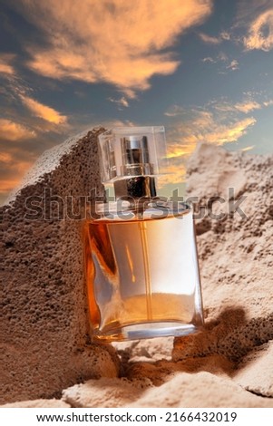 Bottle with a perfume. natural background with sand and stone on the sunset. The concept of beauty and health, organic cosmetics, perfumes, aromatherapy. selective focus