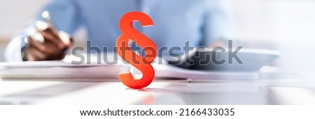 Close-up Of A Red Paragraph Symbol In Front Of Person Working At Workplace Royalty-Free Stock Photo #2166433035