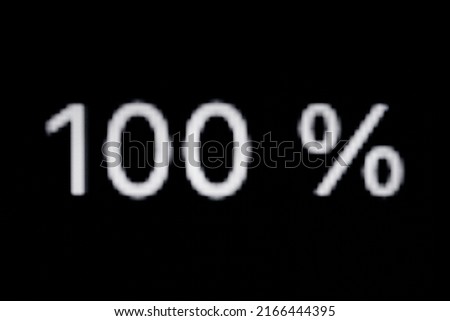 White pixel number one hundred - 100 percent on display, screen of smartphone, tablet, black background - close up macro view. Symbol, discount, promotion, sale and abstract concept