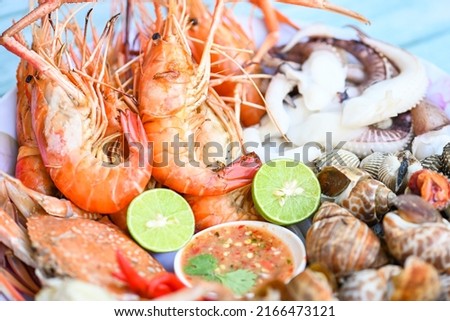 seafood plate with shrimp shellfish crab squid cockle spotted babylon with seafood sauce chili lemon lime serve on dining table, shrimps prawns seafood buffet menu cooked food Royalty-Free Stock Photo #2166473121