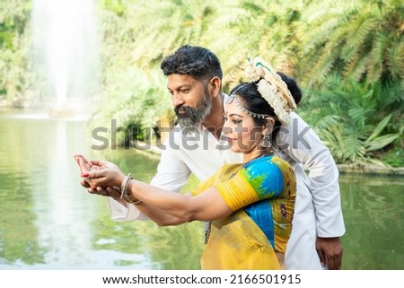 Indian woman learning Odissi classical dance form, male teacher or coach teaching female dancer and correcting pose, Orissi dance, art and culture of india. Royalty-Free Stock Photo #2166501915