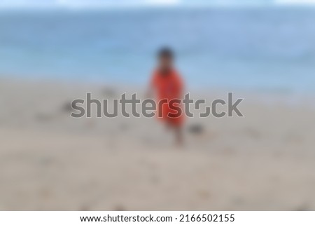 a blurry photo of a child running on the beach                               