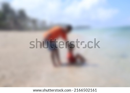 a blurry photo of son and father on the beach                              