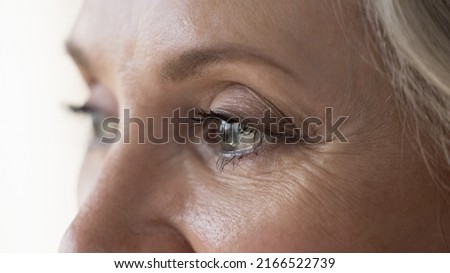 Middle-aged attractive woman looks into distance, cropped close up upper face view. Eyesight, vision care, ophthalmology clinic advertisement for older, eye-care, disease prevention, treatment concept Royalty-Free Stock Photo #2166522739
