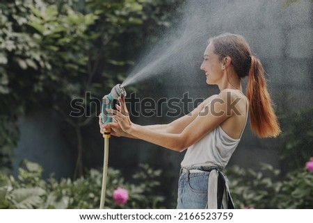 girl enjoying water in the heat of summer in the garden