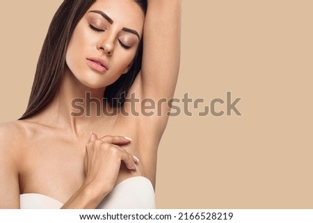 Armpit epilation, lacer hair removal. Young woman holding her arms up and showing clean underarms, depilation smooth clear skin .Beauty portrait Royalty-Free Stock Photo #2166528219