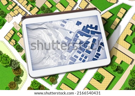 Imaginary cadastral map of territory with buildings, land parcel and green areas with trees - concept with a digital tablet Royalty-Free Stock Photo #2166540431