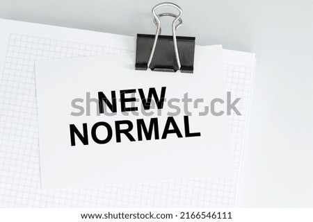 the words New normal on the card on the clip, medical concept