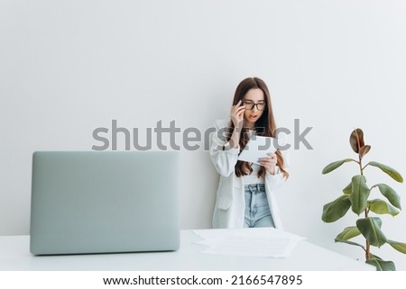 Elegant businesswoman standing in office with notebook and pen