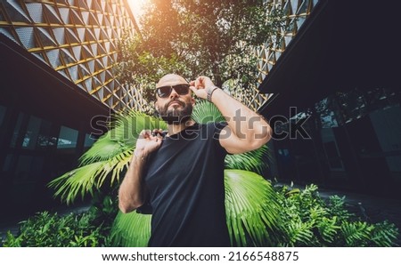Portrait of a fashion young man at beautiful green leaves background in jungle