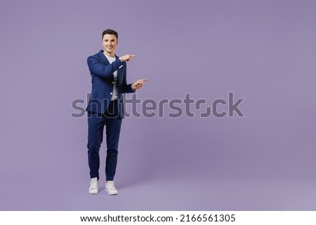 Full size fun young employee business man lawyer 20s wear formal blue suit white t-shirt work in office point on workspace area copy space mock up isolated on pastel purple background studio portrait Royalty-Free Stock Photo #2166561305