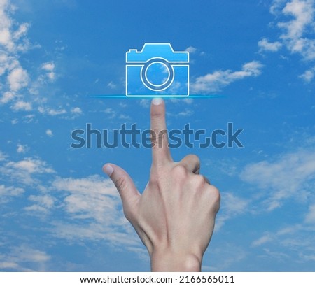 Hand pressing camera flat icon over blue sky with white clouds, Business camera service shop online concept