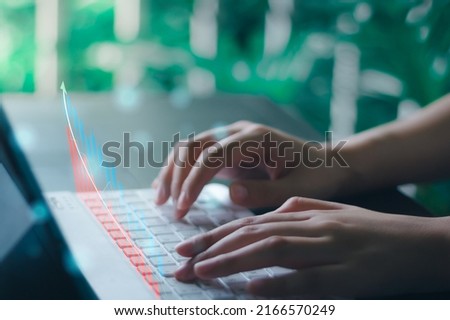 Business women hand typing keyboard to checking stock market on internet, relaxing in green garden.