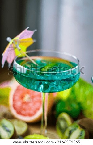 alcoholic drinks in a glass on a wooden board with lemons and grapefruit, kiwi