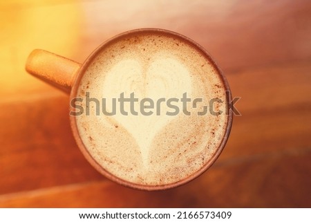 cup of coffee or hot chocolate on the wooden background in cafe