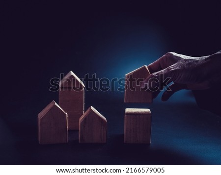 Close up hand establishes a toy wooden house,investment concept. Royalty-Free Stock Photo #2166579005