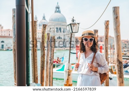 woman in white clothes with straw hat at pier basilica santa maria della salute on background summer vacation