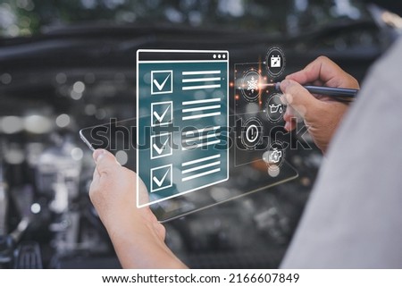 Car business concept and technology on virtual screen, Serviceman use tablet check item list of car mileage for maintenance and service with the engine room in the background,Smart work of car service Royalty-Free Stock Photo #2166607849